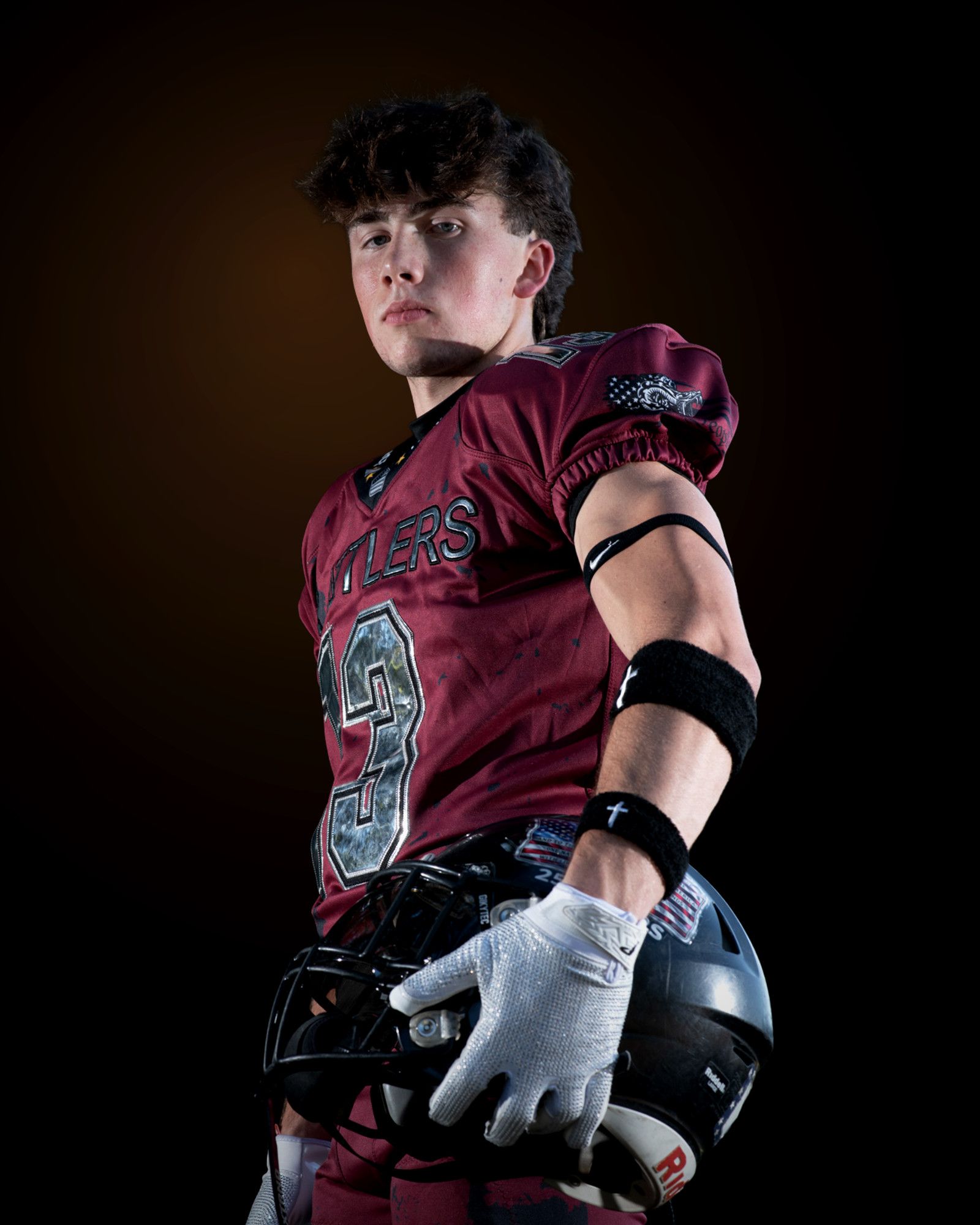 Jack Shepherd in his maroon Rattlers jersey, helmet held low in both gloved hands, looking directly into the camera.